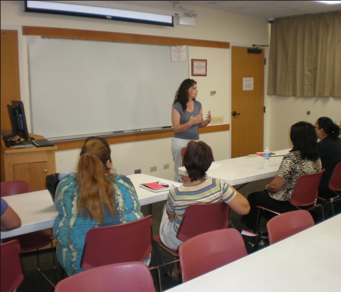 A FLAP attorney leads a workshop for a small group in a library meeting room.