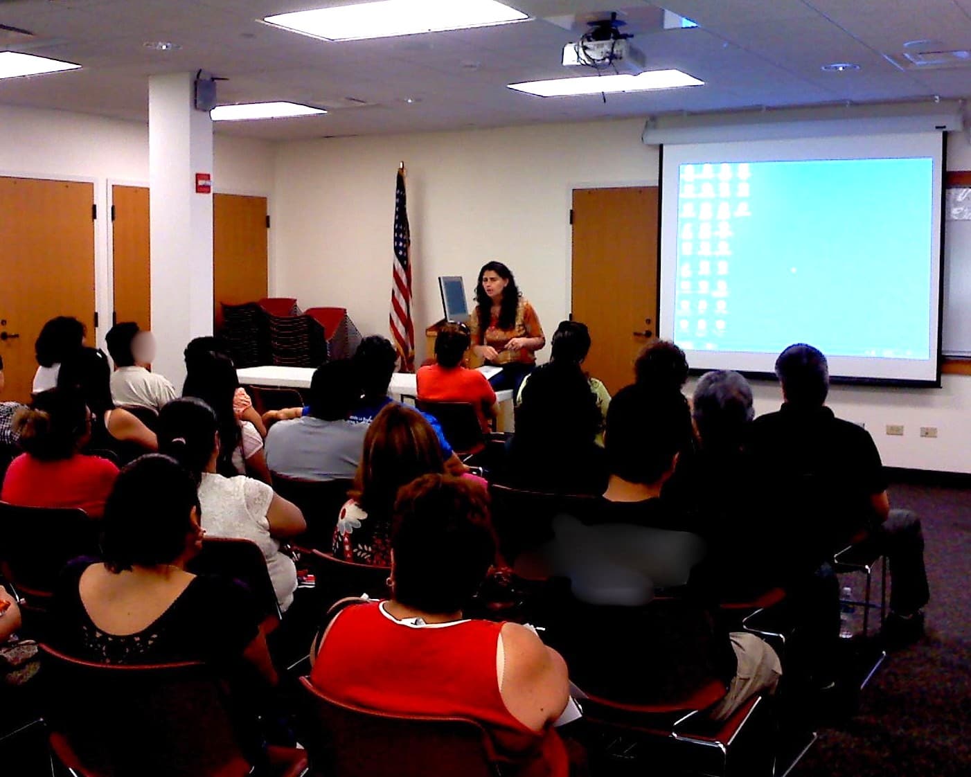 A FLAP attorney presents a slideshow to a packed room at a public library.